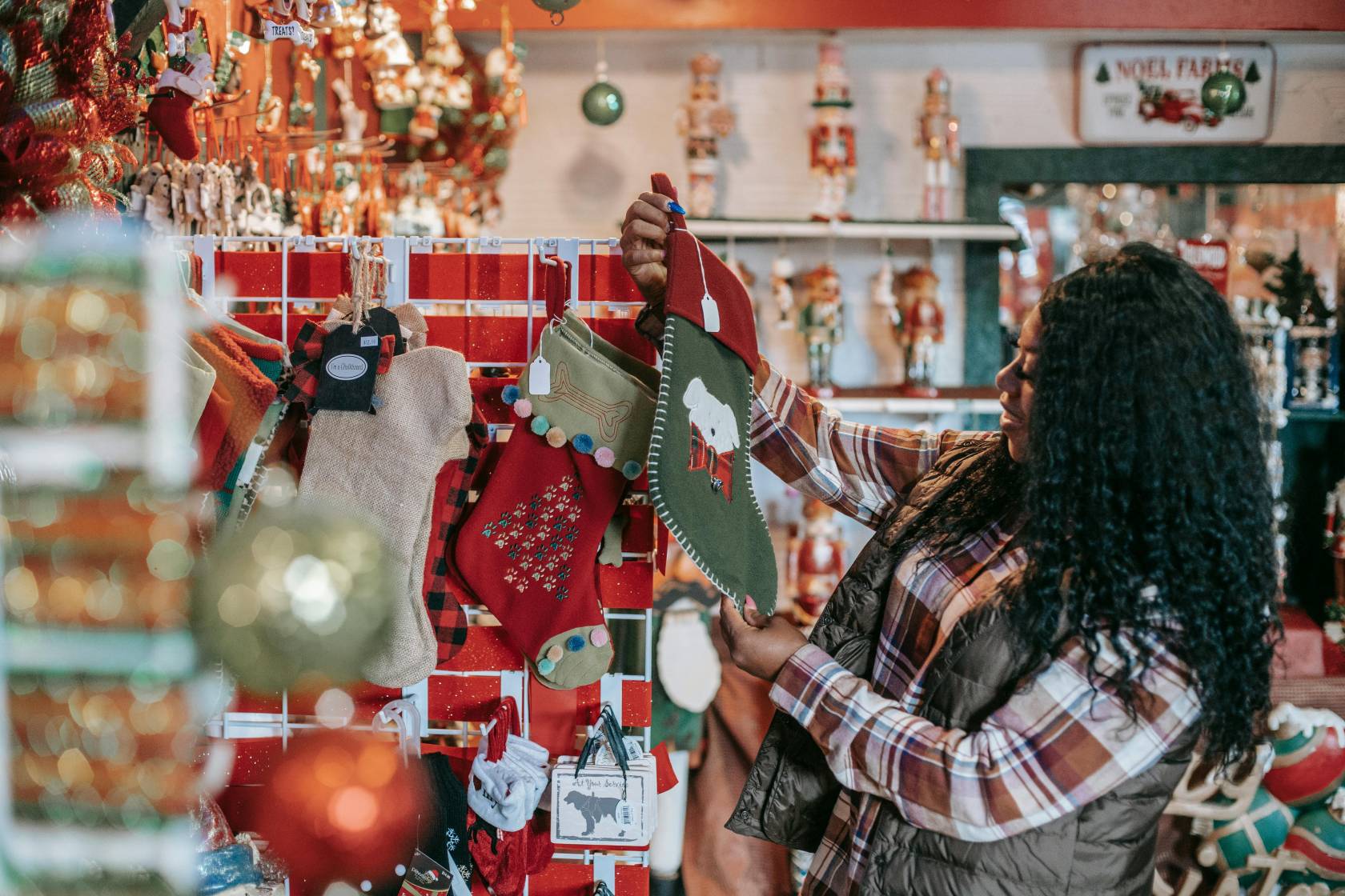 Christmas-themed craft person wearing a top with the text "TREATS?" in a retail store setting.